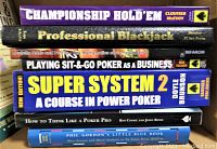 Stack of seven poker and gambling strategy books including titles Professional Blackjack, Phil Gordon's Little Blue Book, Super System 2, Championship Hold'em, Playing Sit & Go, Roulette, How to Think Like a Poker Pro.