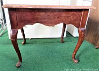 Front angle view of vintage Thomasville side sofa table showing curved legs and scalloped apron.