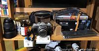 Shelf with Kowa 35mm film camera, Nikon lenses, VuPoint film and slide converter box and assorted photography accessories