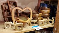 Wide view showing all items on shelf including bowls, napkin rings, heart bowl, animal figures, and wicker container.