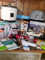 Panoramic view showing all kitchen gadgets including rice cooker, spiralizer box, hand blender, toaster, vacuum sealer box and yogurt maker box.
