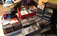 Cardboard boxes and stacks of jazz CDs on table and couch