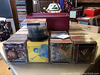 Clear acrylic organizer on table filled with music CDs and empty CD spindle pack