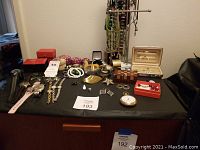 Overview of watches, jewelry, decorative boxes, and necklace rack on black cloth