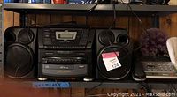 Photo of JVC stereo system with 10 CD changer, speakers, and big button phone in garage setting