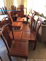 Full view of six wooden dining chairs, five side chairs, and one armchair with matching design.