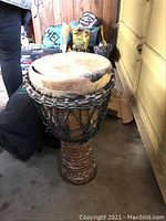 Hand-carved wooden djembe drum with goatskin head and carved pattern