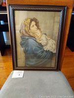 Framed print of Italian mother and child sitting on chair, showing front view of artwork and frame details.