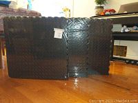 Three packages of black foam puzzle mats in unopened packaging, each package contains 4 sq ft mats totaling 12 mats in all.