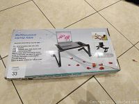 Image of unopened box with product name and images showing the multifunctional folding laptop table with laptop arranged on it and rose decorations on the box.