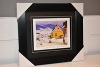 Photo of professionally framed and matted "Yellow House" print, showing overall presentation with black frame and corner protectors.