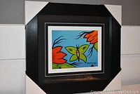 Framed and matted art print titled 'Butterfly and Flower' by David Morriseau in black frame with white corner guards.