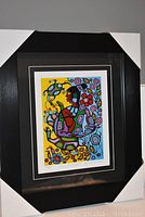 Front view of framed print showing artwork, black frame, and protective corner covers