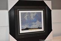 Front view of professionally framed and matted fine art print 'Cloudy Sky' by JEH MacDonald, showing the full frame and matting with corner protectors.