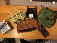 Overview of five handbags and Koss CD player/alarm clock on wooden surface.