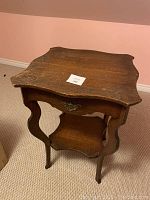 Top angled view showing the scalloped edges and wood grain of the antique wood table.