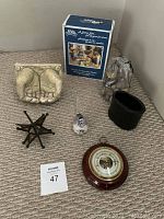 Overview photo showing all items on beige carpet including pottery hands, iron star, glass bird, black pot, barometer, and UV3 kit box