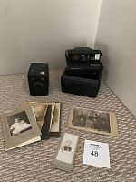Photo showing antique Six-20 Popular Brownie Kodak film camera, vintage Polaroid Instamatic camera with case and strap, and 8 vintage portrait photos.