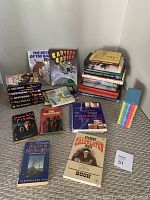 Full lot showing various fiction and reference books laid out on carpet