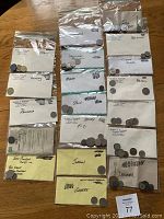 Photo showing labeled plastic bags containing coins from Panama, Spain, Fiji, Malta, Jordan, Greece, Denmark, Brazil.