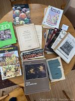 Overview of assorted art and culture magazines and books arranged on a wooden table, showing various titles and covers.