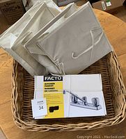 Wicker basket with the sealed Facto kitchen faucet box inside showing the items together
