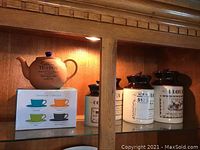 Earthenware country tea pot, set of four ceramic canisters with printed labels.