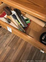 Drawer showing a rolling pin, metal rasp, and additional kitchen tools.