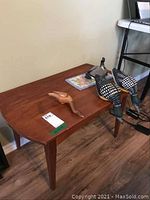 Small teak table with three carved waterfowl figures and small wool punch needle mat on top, showing overall condition and details of figures.