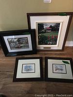 Four framed prints arranged on a floor, showing varied sizes and scenes of Nova Scotia landmarks including the Public Gardens and lakeside scenes.