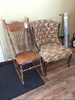 Photo showing both solid wood nursing rocker with carved back and tufted floral upholstered chair side by side on wooden floor