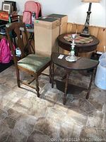 Photo showing demi lune table, dining chair with green cushioned seat, and small bedside lamp on table