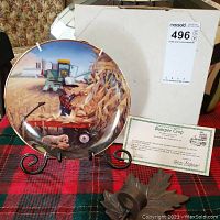 Photo showing the Zolan "Bumper Crop" collector plate set on a black metal stand with certificate and cast iron leaf tealight holder in front.