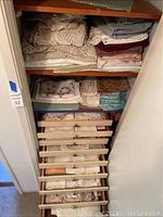 Shelving unit with folded linens and pull-out drawer below