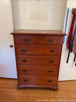 Front view of the 6-drawer wood highboy dresser showing drawer layout and handles.