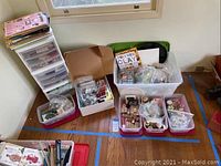 Photo showing multiple plastic bins and drawers filled with assorted crafting supplies including polymer clay, buttons, beads, and metal components.