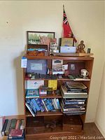 Full view of oak veneer shelf unit loaded with assorted items