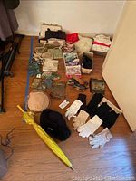 Overall assortment of handbags, purses, coin purses, hats, gloves and umbrella on floor