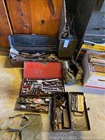Top view of several metal tool boxes containing socket wrench sets, ratchets and other hand tools