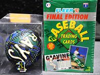 Photo showing the sealed box of Fleer '93 Final Edition baseball trading cards and the Tampa Bay Devil Rays decorative baseball in clear display case from the front.