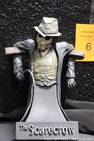 Front view of The Scarecrow mini-bust figurine showing the torso, outstretched arms, and base with text.