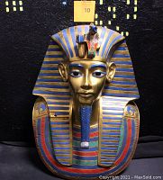 Close-up photo of the colorful King Tutankhamun head bust wall art showing detailed painted features and striped headdress.
