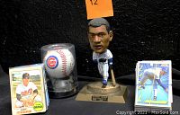 Full set view showing MLB trading cards grouped by rubber bands, Cubs autographed baseball in clear plastic case, Sammy Sosa figurine on base stand