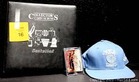 Black padded basketball collector's album with a Minneapolis Lakers cap and an autographed basketball card displayed in front.