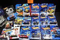 Overview of the 19 assorted Hot Wheels and Muscle Machines 1:64 scale die-cast cars in original packaging, showing variety of models and branding.