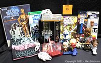 Overview of the Star Wars collectibles lot showing books, various toys and figurines, Pez dispensers, the Star Wars Trilogy VHS box set, T-shirt, and other memorabilia.
