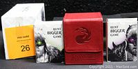 Closed white collector's box with Magic: The Gathering character artwork and two smaller deck boxes plus the red Ultra Pro card case all shown together.