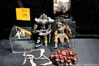 Two McFarlane Monsters 6 Faces of Madness action figures and accessories on black background