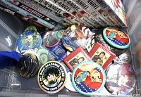 Photo showing assorted anime and manga pin backs and pins including Anime Expo 2016 My Hero Academia button and various other colorful pins.