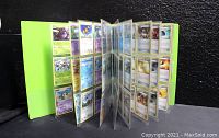 Open neon green binder showing pages filled with Pokemon trading cards.